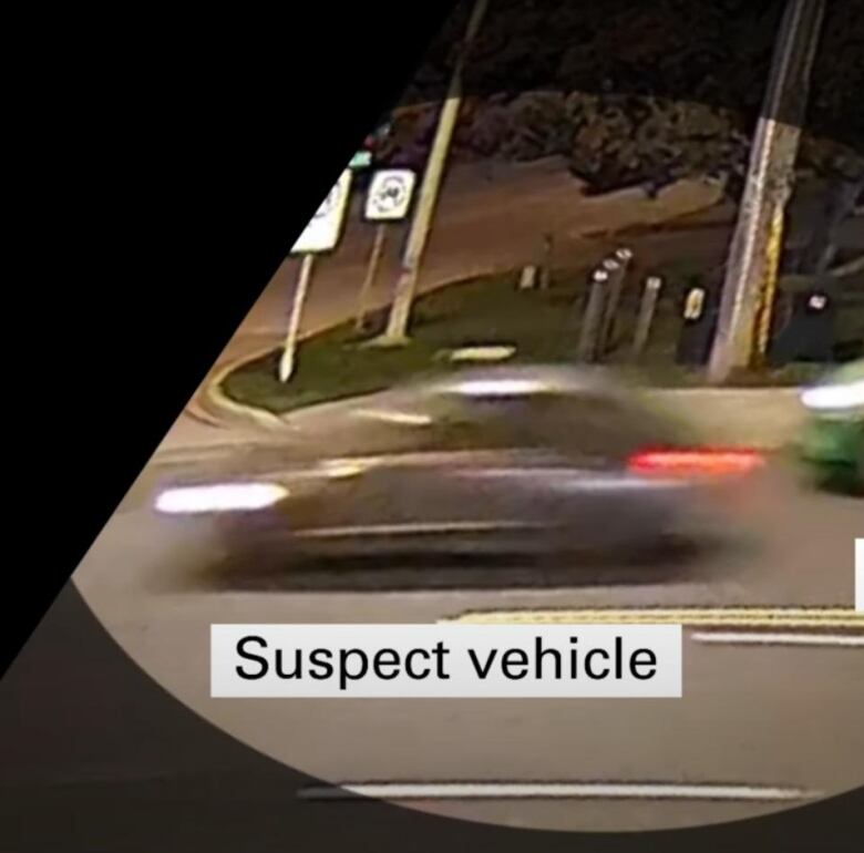 A car going by security footage with a graphic that says 'suspect vehicle.'