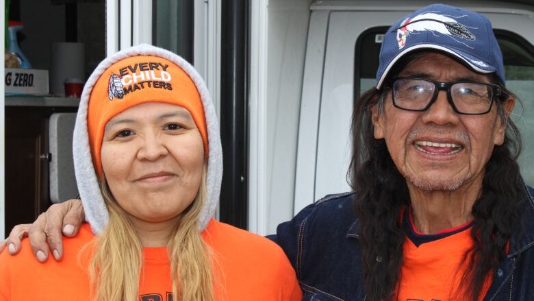 An Indigenous woman and her father wearing Orange shirts 