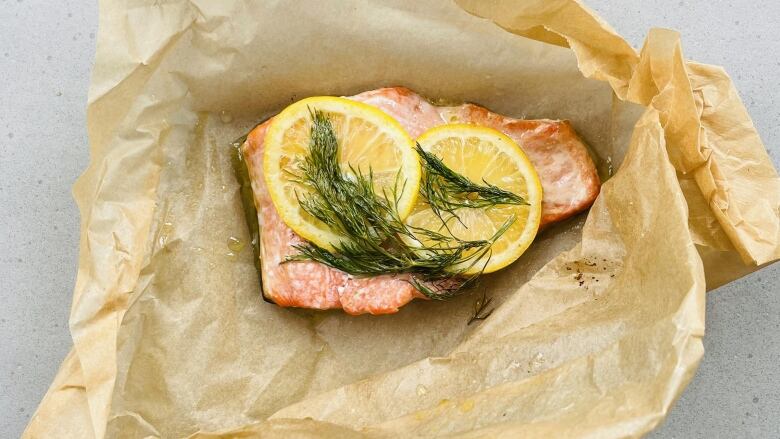 A fillet of salmon sits in parchment paper.