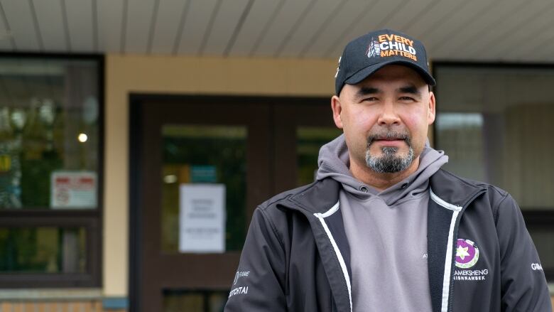 Craig looks at the camera as he stands in front of the band office.