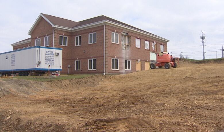 A brick building with cleared land beside it.