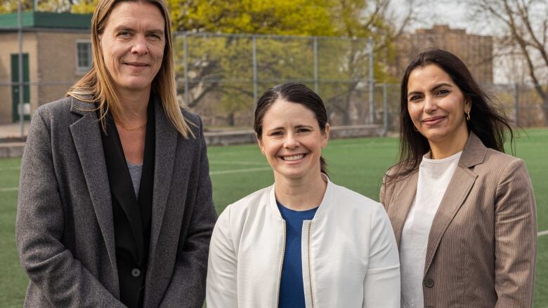 Three woman pose for a picture.