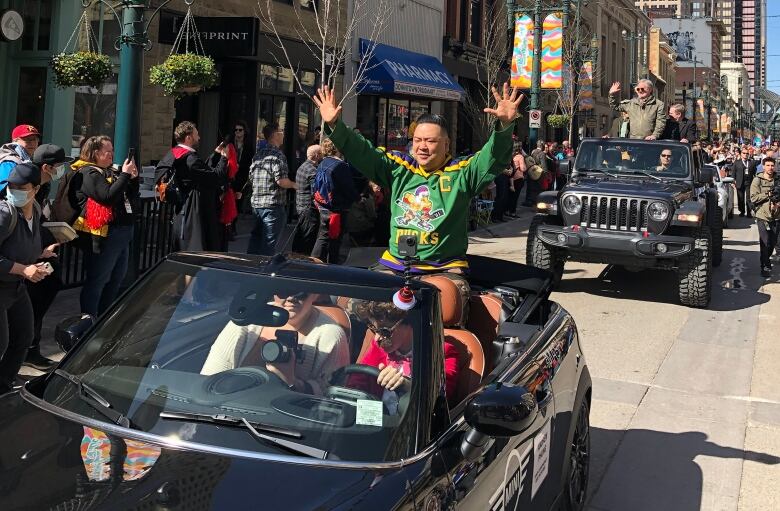 People in cars go through the parade.