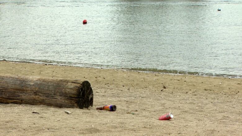 A beer bottle and a can littered on English Bay Beach in Vancouver on Saturday, April 29, 2023.