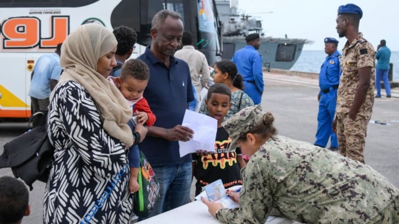 A family shows documents to a soldier.