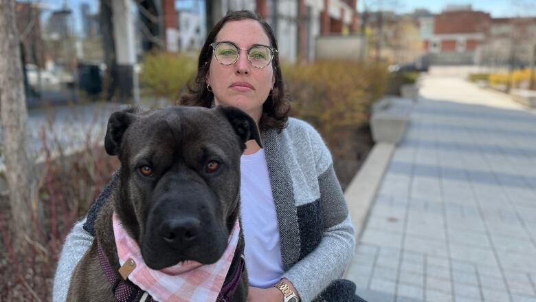 Woman sitting infront of condo building with her dog.