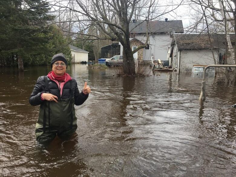 A woman stands in knee-deep water.