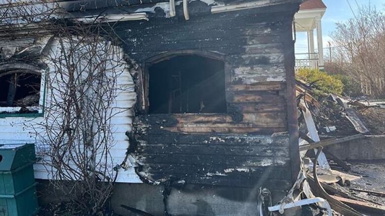 An exterior shot of a porch heavily damaged by smoke and fire.