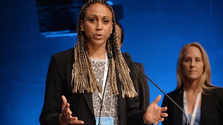 A woman speaks at a lectern.