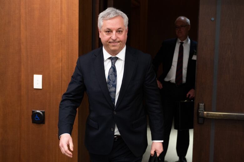 Director of the Canadian Security Intelligence Service (CSIS), David Vigneault smiles as he enters a room.