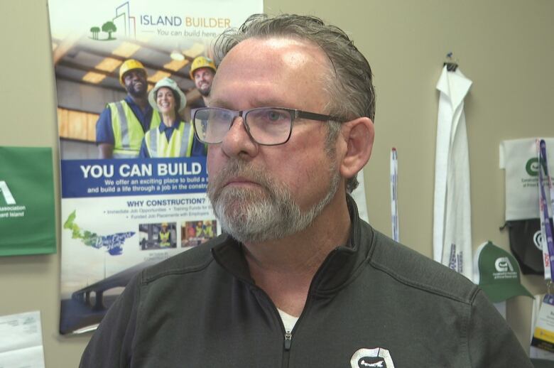 Sam Sanderson in front of a tradespeople recruitment poster.