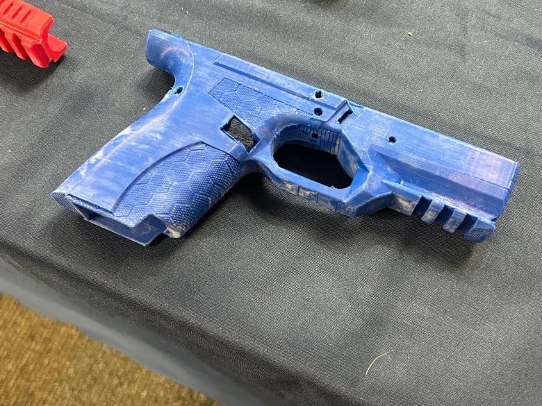 A close up of a blue 3D-printed gun handle. 