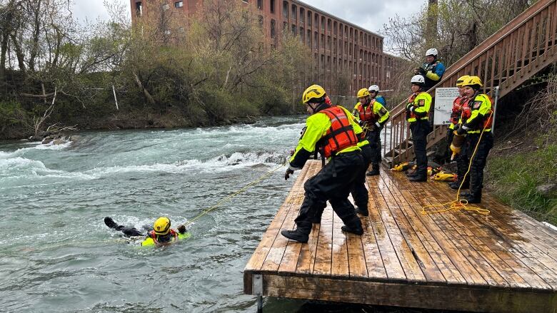 guys pulling each other out of the river. 