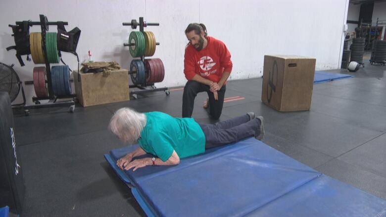 94-year-old Christine Temple-Fentimin works on her burpees during a Wednesday training session with Adam Phomin at CrossFit Closer.