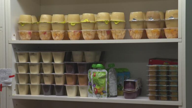 Canned pudding and fruit on a food bank shelf