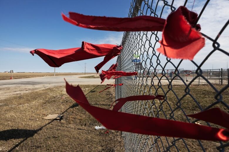 Red dresses and ribbons are seen blowing in the wind outside of the Brady Road landfill.