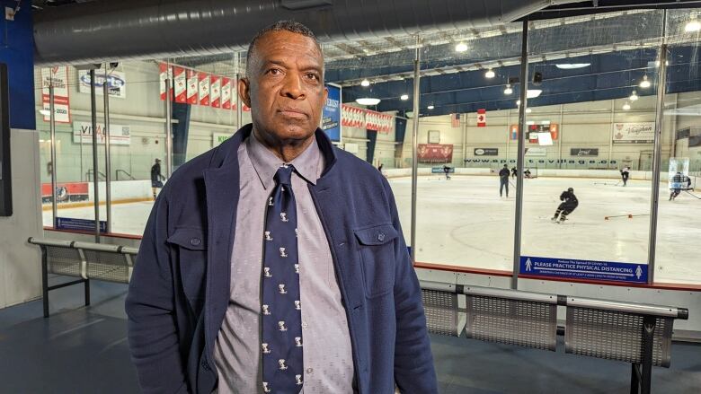 Karl stands in front of an indoor hockey rink. 