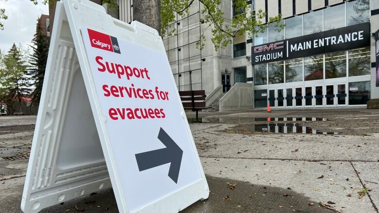 A sign directing wildfire evacuees to the Stampede Grandstand building.