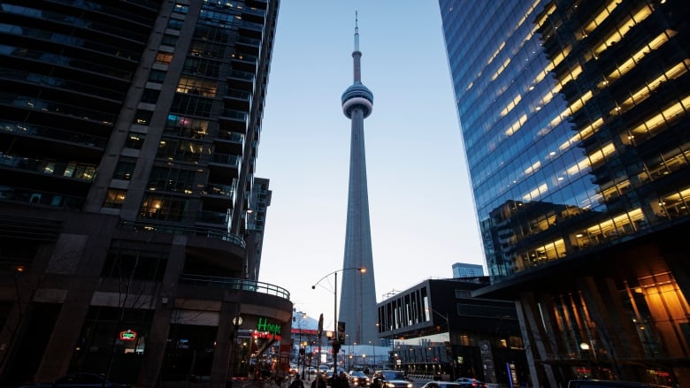 The CN tower seen between two other high rises at dusk.