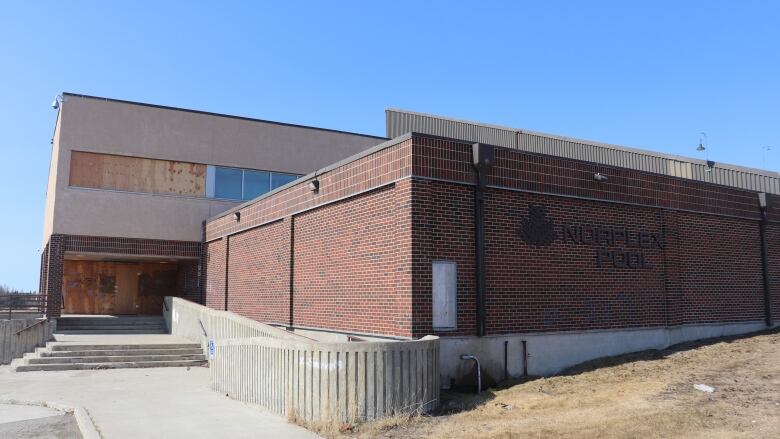 A red bricked building, with an entrance to the left side, that has sign on the front which reads 'Norplex Pool'