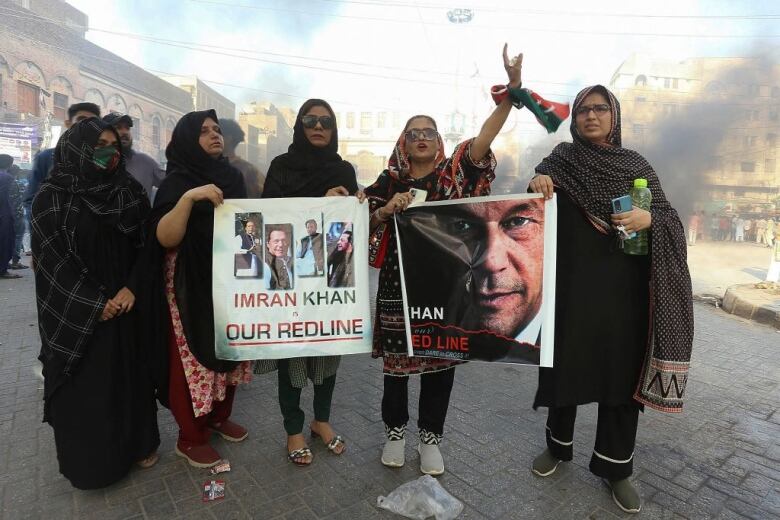 Four women hold posters supporting former Pakistan prime minister Imran Khan at a protest in Hyderabad, Pakistan.