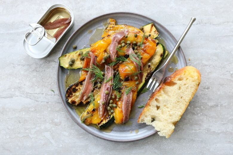 A dish with vegetables and tinned fish.