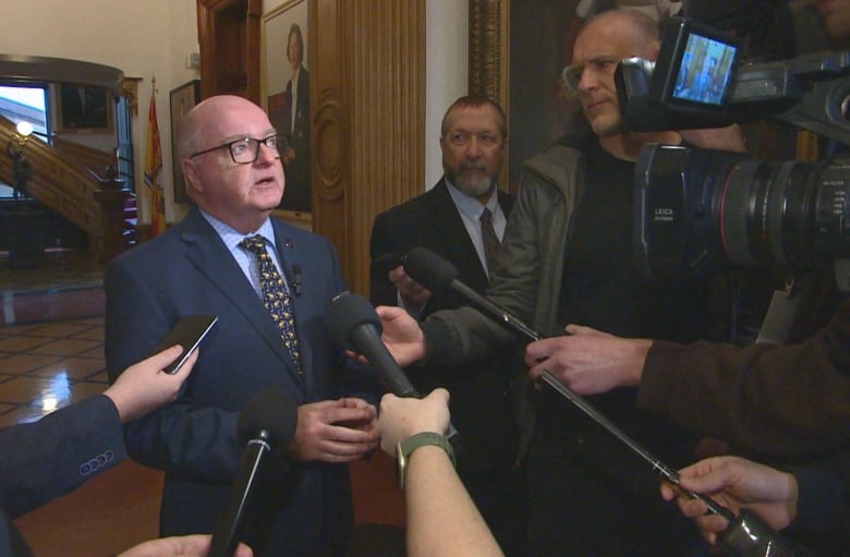 Man surrounded by cameras and microphones