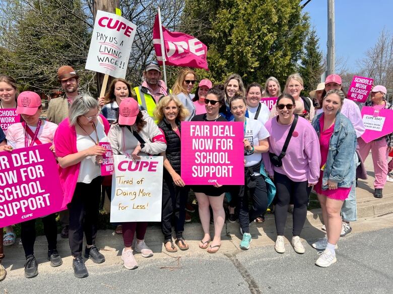 Teachers standing with CUPE members on the picket line during lunch break at Burton Ettinger Elementary School holding pink signs. 