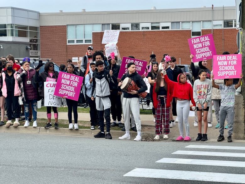 Students holding signs on the picket line to show support for strikers