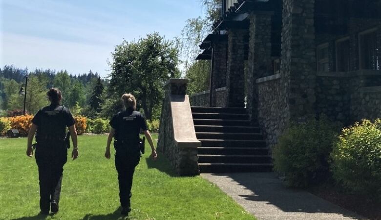 Two conservation service officer search Deer Lake park in Burnaby for a coyote.