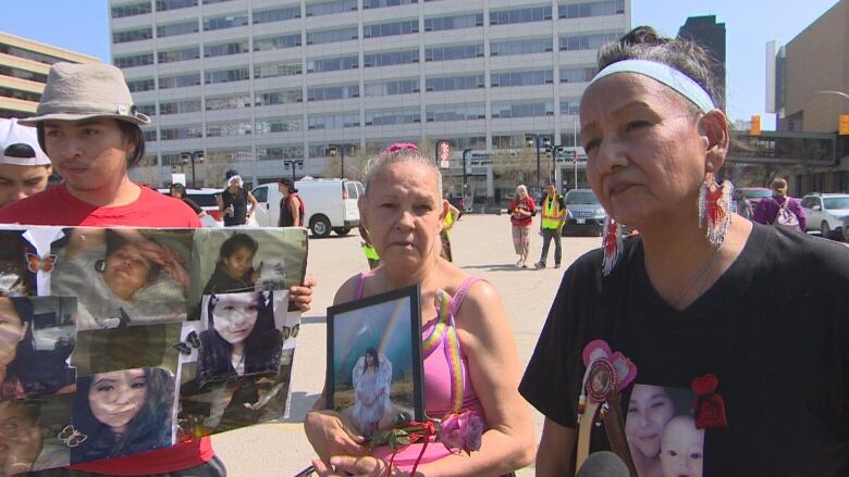 Three people are pictured. Two hold pictures of a woman, while the third wears a t-shirt with the woman's picture on it.