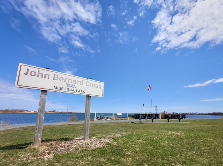 A photo of a sign in front of a body of water saying 