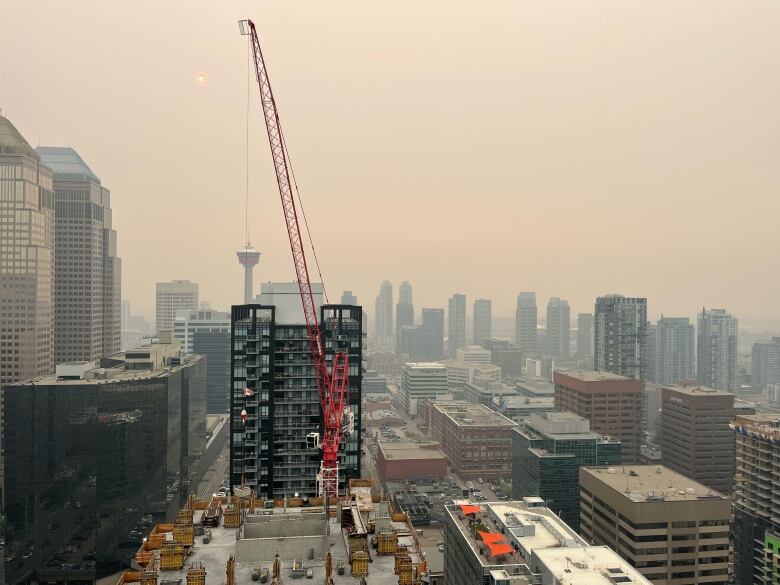 An orange haze blocks out the blue sky over downtown Calgary. 