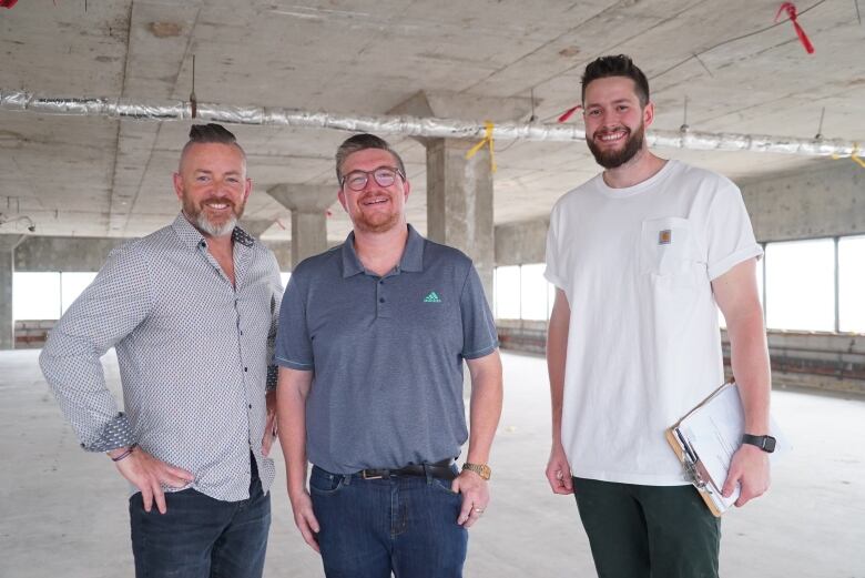 Three men standing in a construction site.