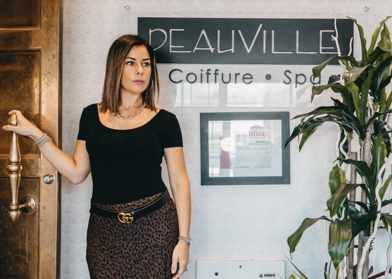 A woman stands in a beauty salon. 