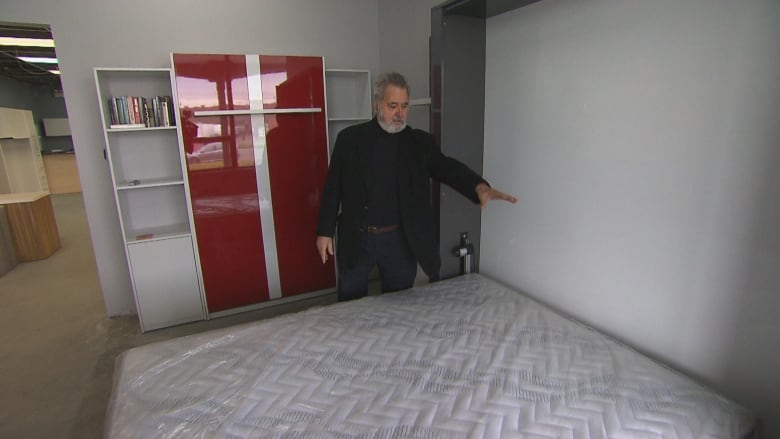 A man points to a murphy bed