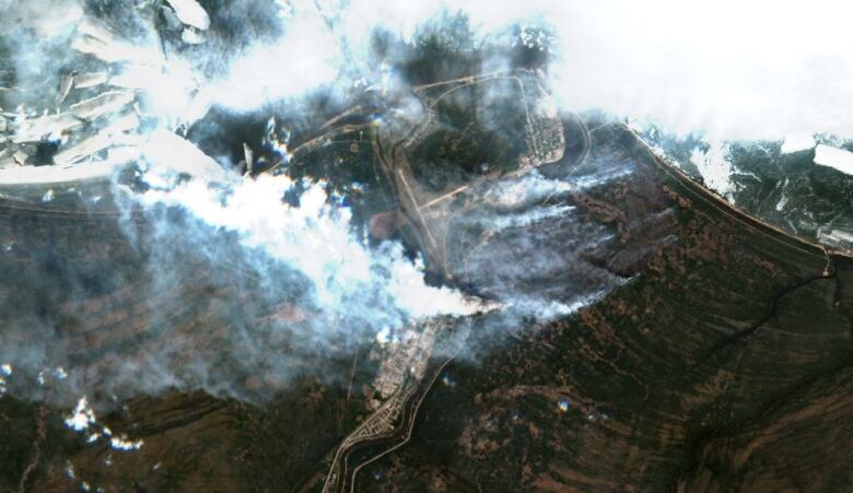 Satellite imagery shows fire burning land at south end of big lake.