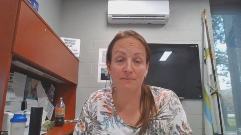 A woman sits at a desk. 