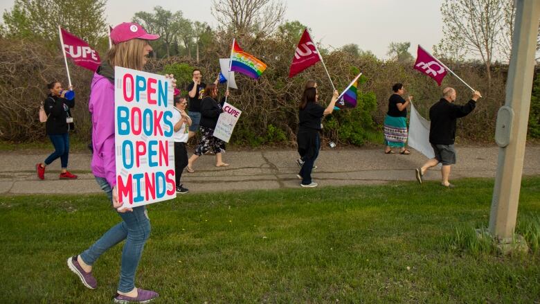 A woman carries a sign says  