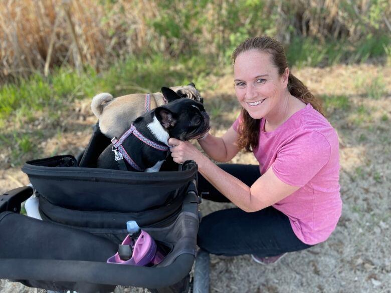 Ann-Marie Fleming with her two dogs seated in a dog stroller.