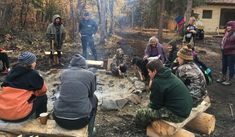 A group of people sitting around a fire.