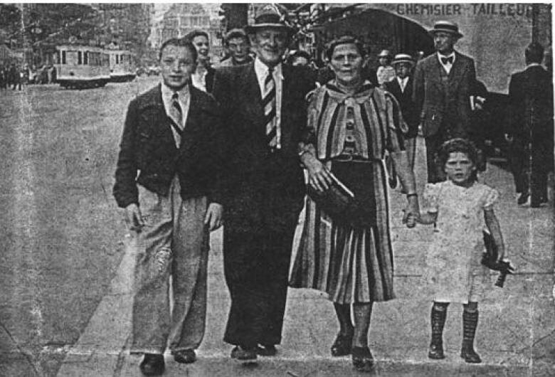 A group of people walk down the street.