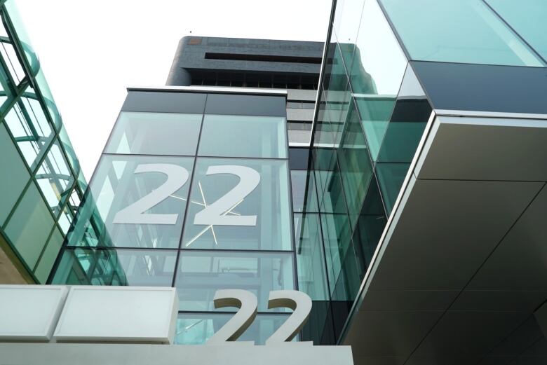 Close up photo of the exterior of a building mostly made of glass with the the unit number on it.