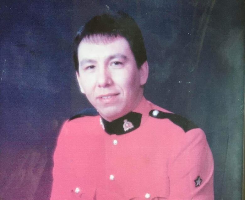 A man posing for a photo in a red RCMP uniform  