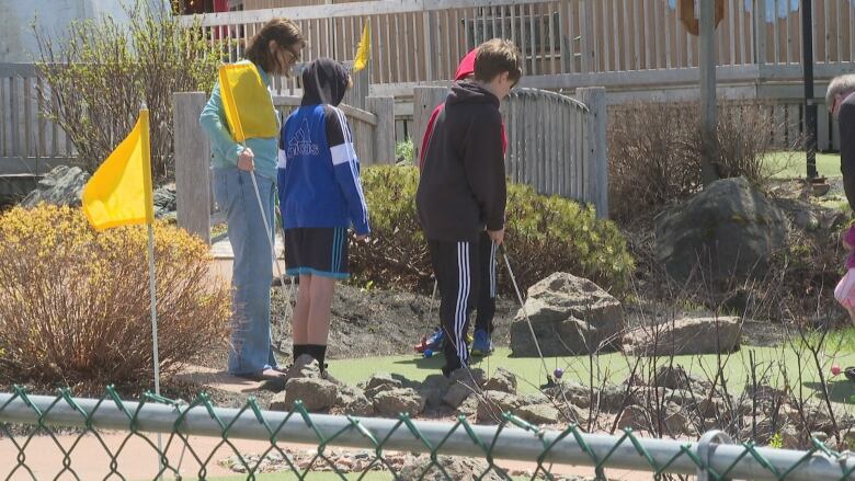 A family plays mini golf in Cavendish. 