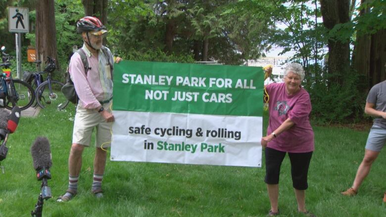 A man and a woman are pictured holding up a large sign that says 