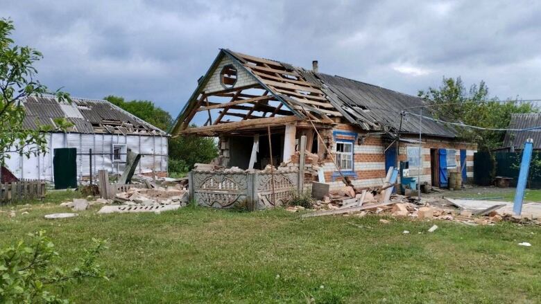 Rubble is strewn around a heavily damaged home.