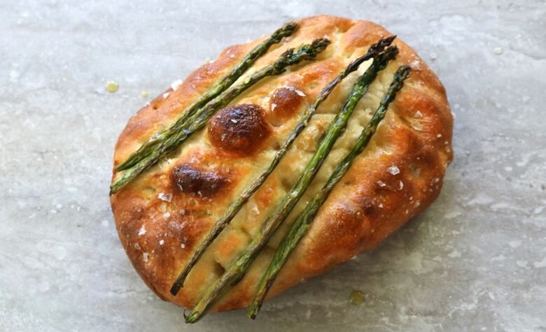 Close-up shot of focaccia bread with green asparagus.