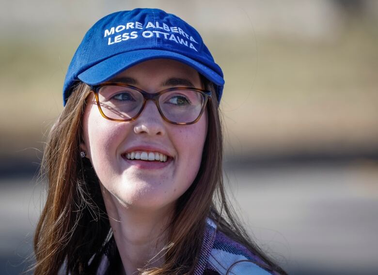 A young bespectacled woman with a blue 