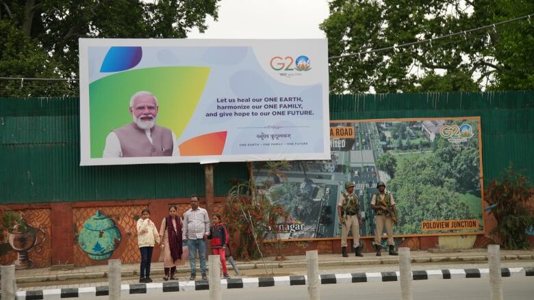 Indian paramilitary soldiers guard the area near Srinagar's revamped, historic Polo View Market while delegates visit the area, under a sign promoting India's run as G20 hosts this year. 